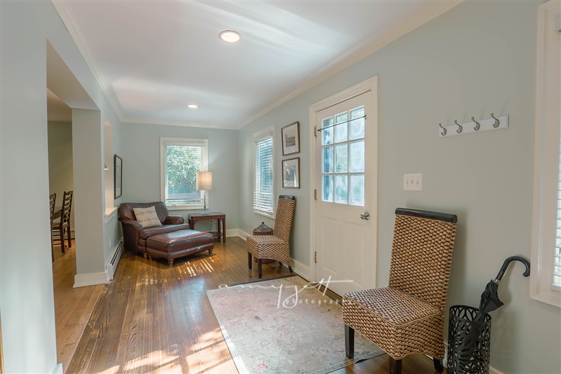Light-filled sitting room with hardwood floors and garden window