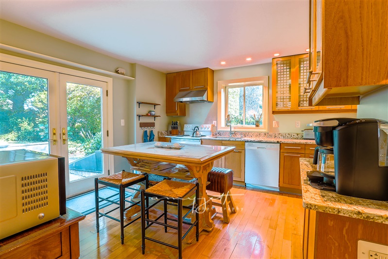 Chef's kitchen with French doors to garden and marble island seating