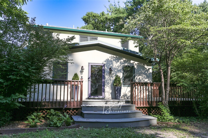 2675 Halfway Road — main residence exterior with wraparound deck and wooded surroundings